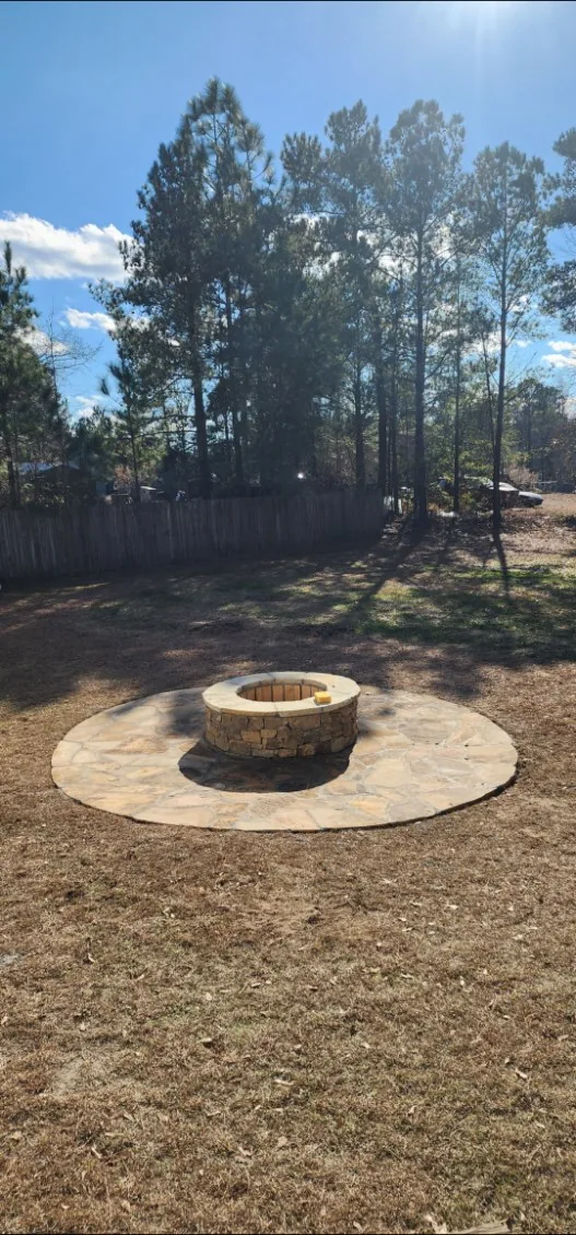 Finished stacked-stone fire pit inside a circle of flagstone